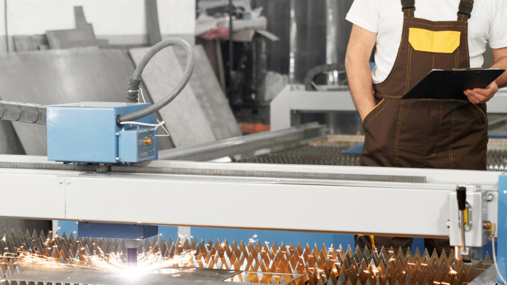 Máquina de corte a laser em operação realizando corte preciso em chapa metálica dentro de uma metalúrgica industrial.
